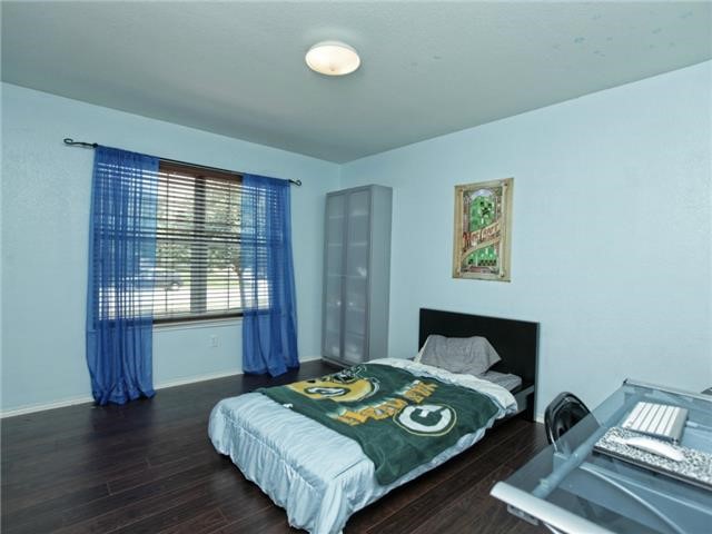 1008 Apollo Circle Round Rock, TX 78664 - Photo 27 of 33 a bedroom with a bed and wooden floor