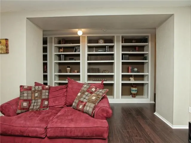 a living room with furniture and a book shelf