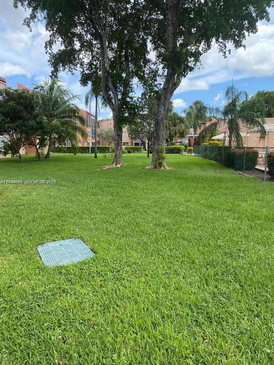 8838 West McNab Road, Unit 104 Tamarac, FL 33321 - Photo 20 of 23 a view of outdoor space with garden and trees