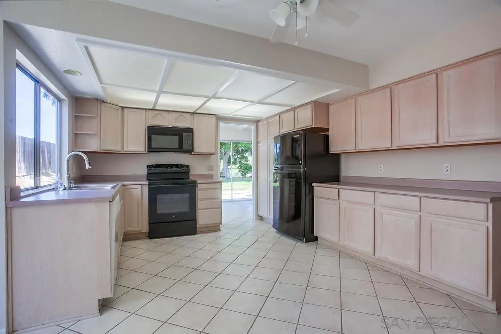 7114 Columbine Drive Carlsbad, CA 92011 - Photo 6 of 16 a kitchen with granite countertop a refrigerator and a stove top oven