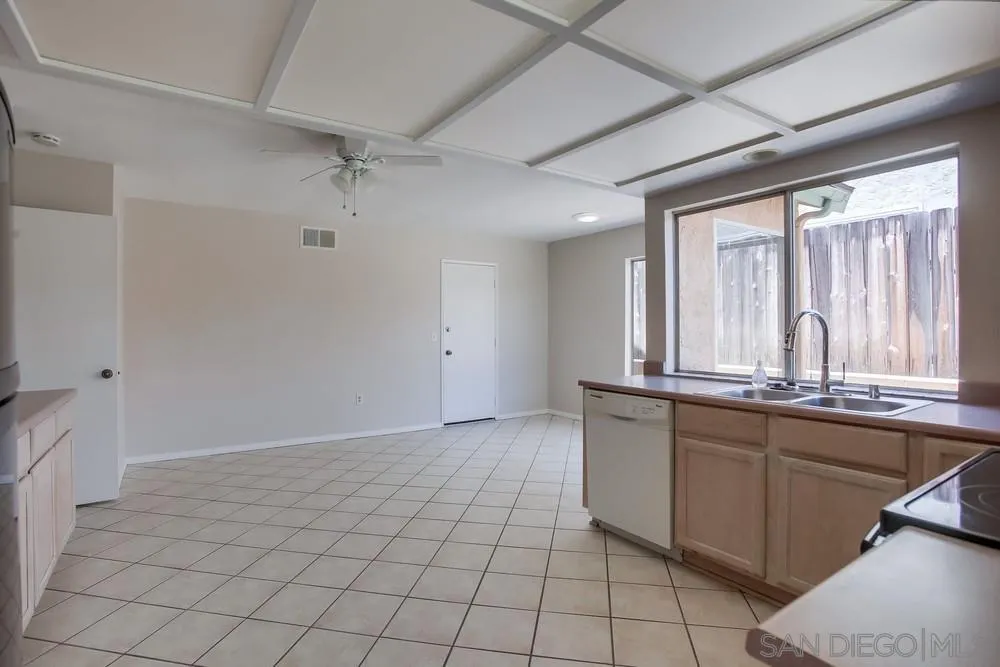 7114 Columbine Drive Carlsbad, CA 92011 - Photo 8 of 16 a large white kitchen with granite countertop a sink and dishwasher a stove with wooden floor