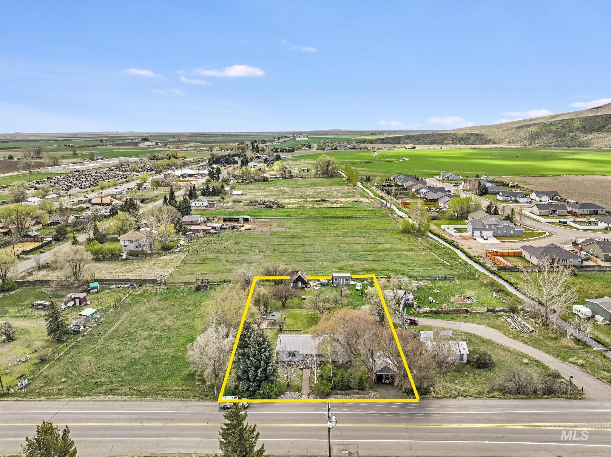 19591 Queen Crown Road Carey, ID 83320 - Photo 37 of 37 Aerial perspective showcasing a property outlined in yellow, featuring a residential structure, mature trees, and a detached outbuilding