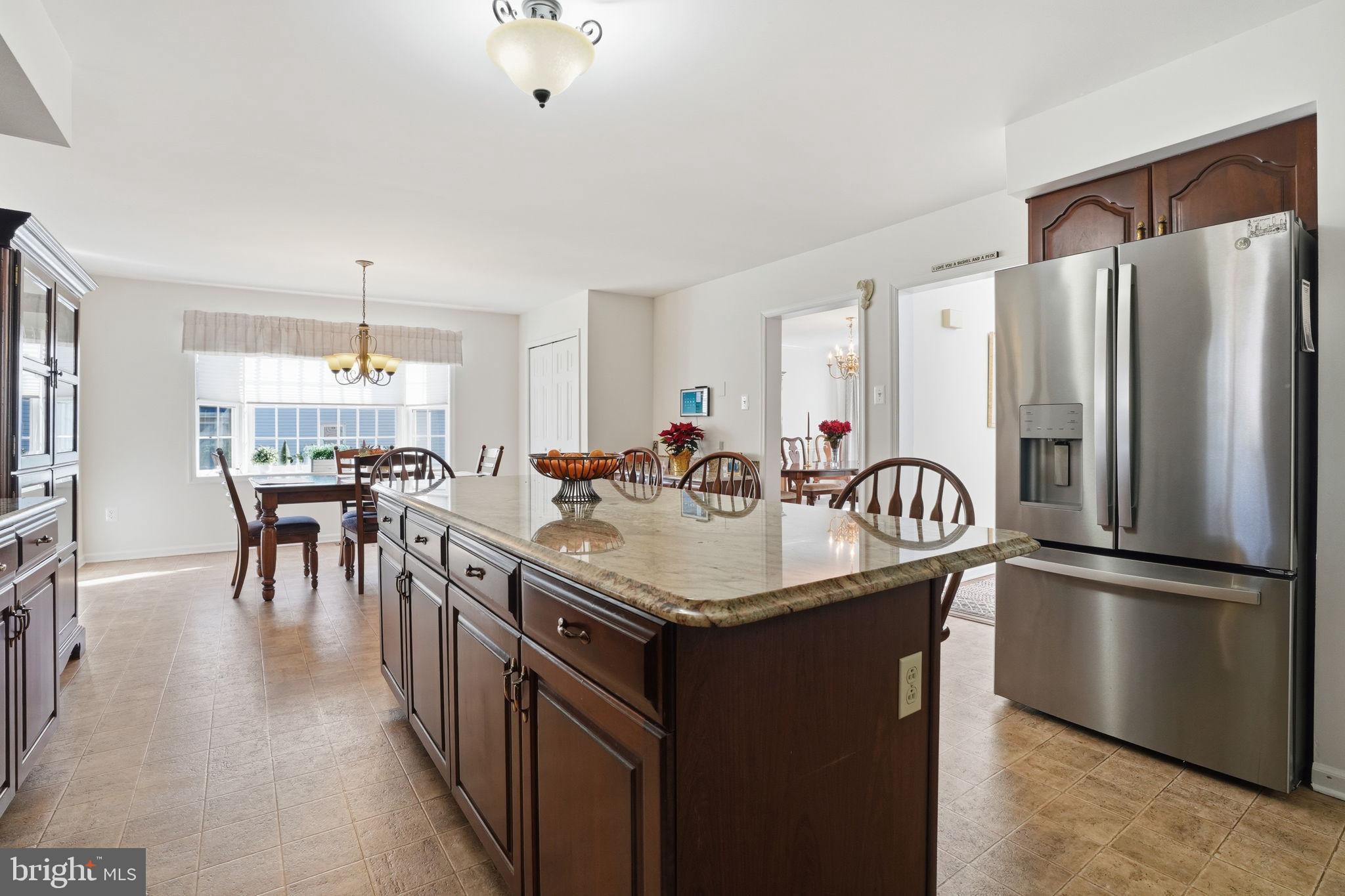 3 Swallow Road Holland, PA 18966 - Photo 11 of 45 a kitchen with stainless steel appliances granite countertop a table chairs a refrigerator a sink a stove and a center island