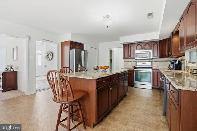 a kitchen with stainless steel appliances granite countertop a sink a stove and a refrigerator