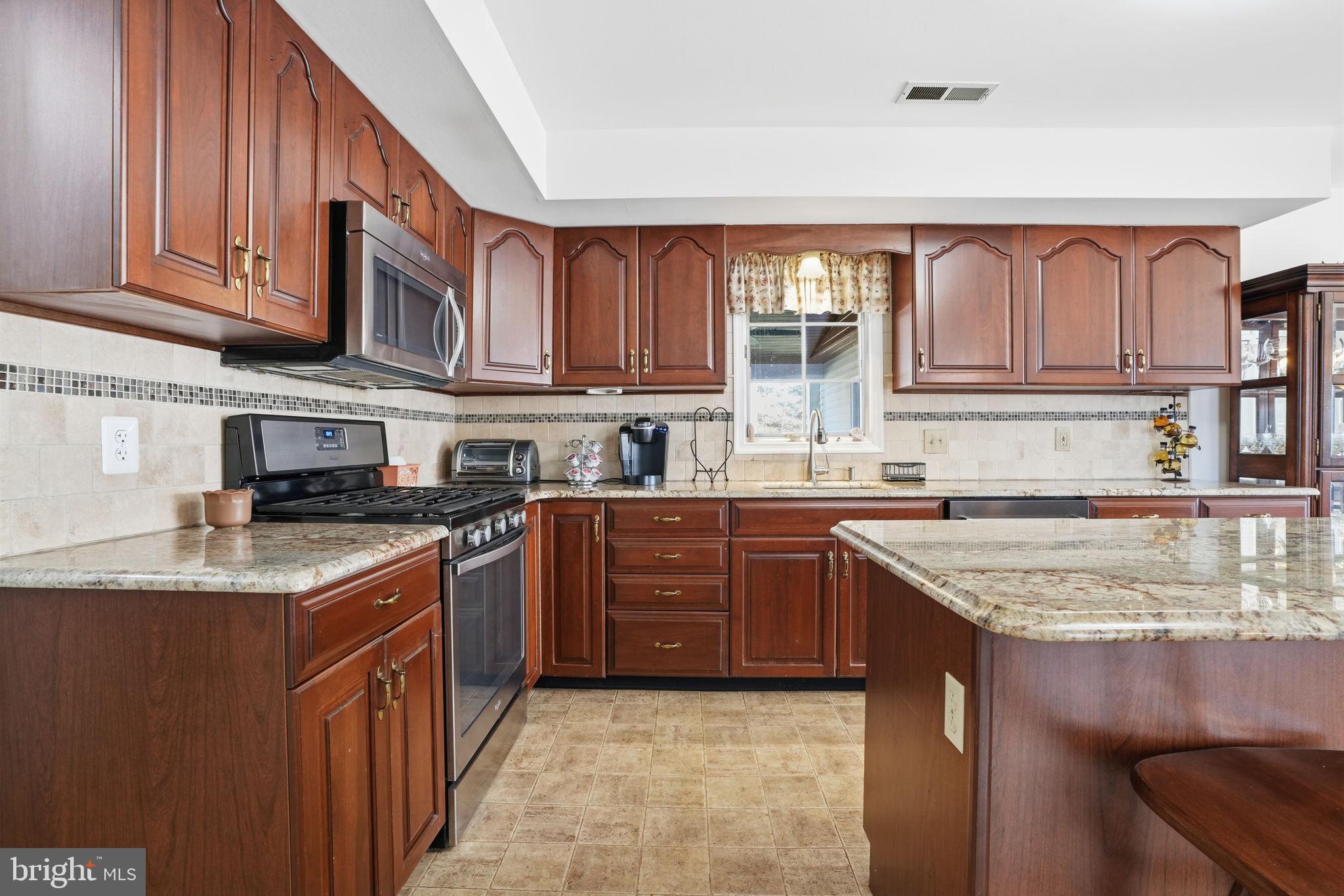 3 Swallow Road Holland, PA 18966 - Photo 15 of 45 a kitchen with stainless steel appliances granite countertop a sink stove microwave and cabinets