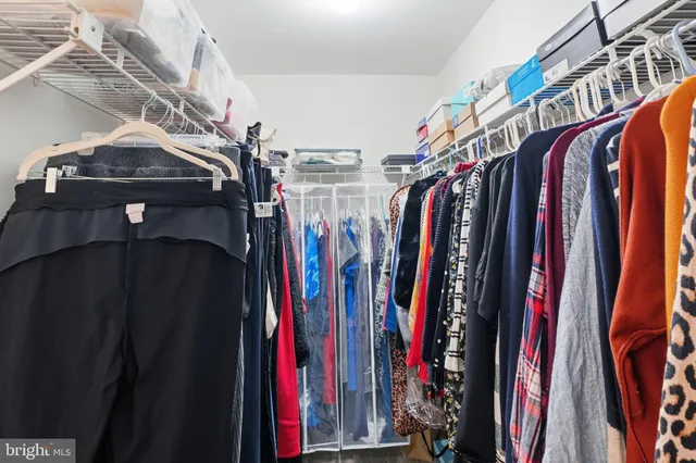 a view of walk in closet with clothes