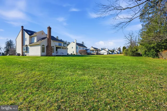 a view of a house with a big yard and large trees