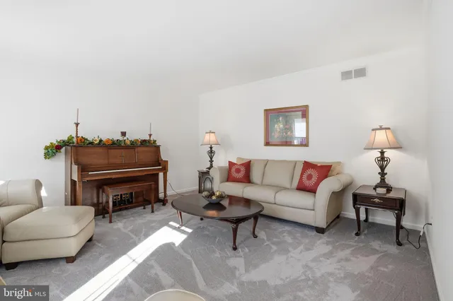 a living room with furniture a piano and a lamp