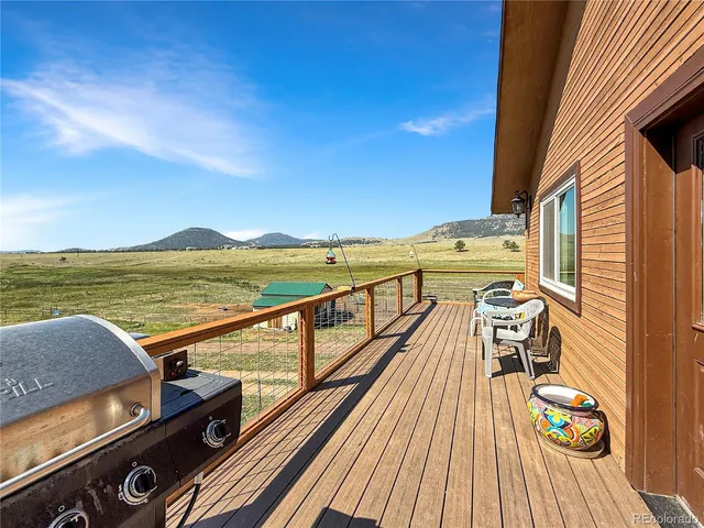 a view of a balcony with wooden floor and outdoor seating