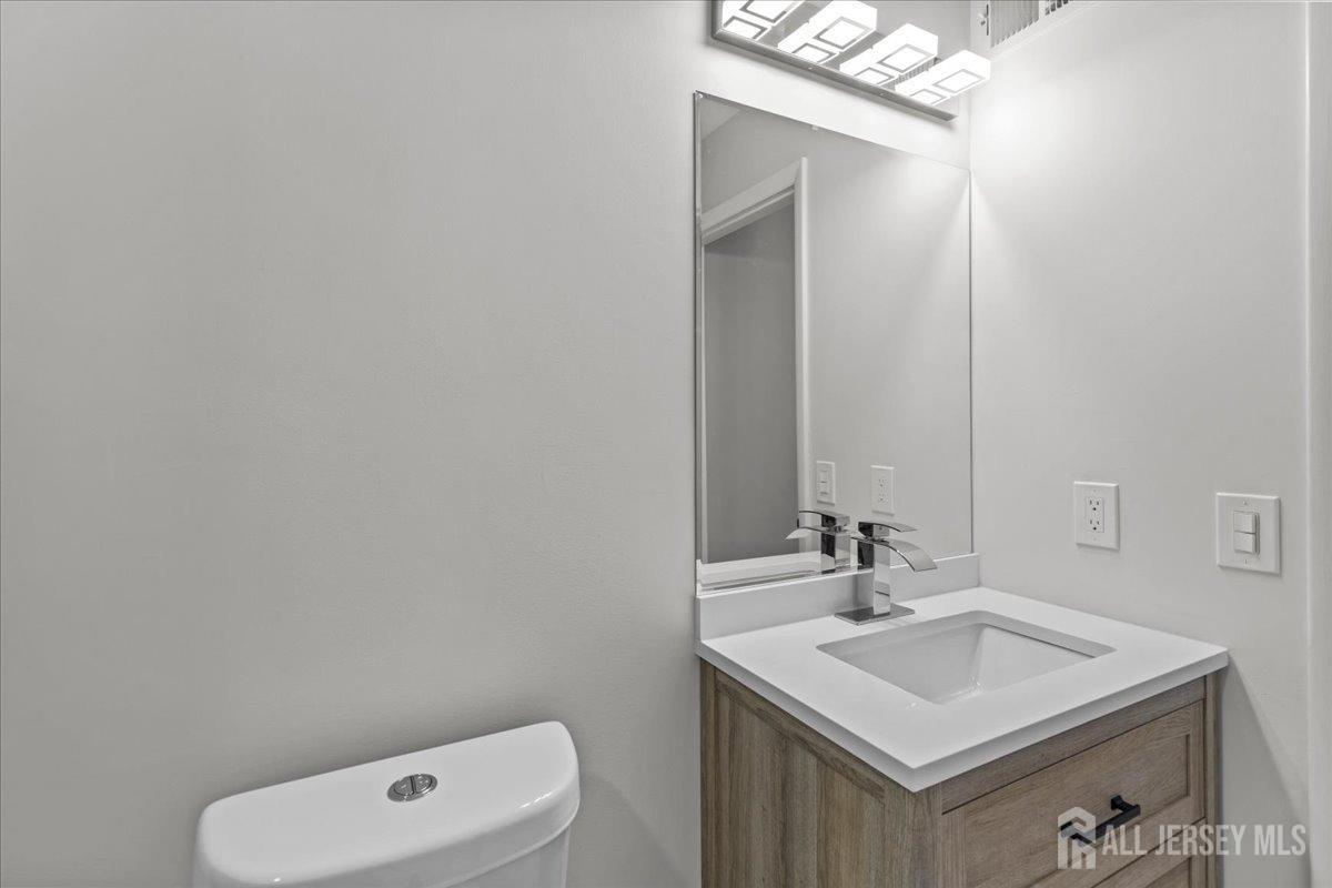 104 Maple Place Keyport, NJ 07735 - Photo 33 of 67 a bathroom with a sink a toilet and a mirror