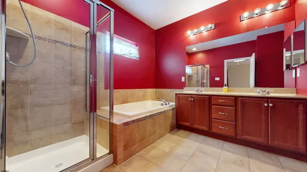 a spacious bathroom with a tub sink shower and mirror
