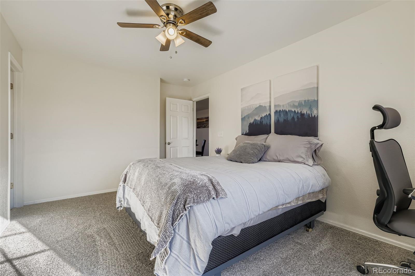 283 Ellers Grove Colorado Springs, CO 80916 - Photo 11 of 17 a bedroom with a bed a chandelier and a window