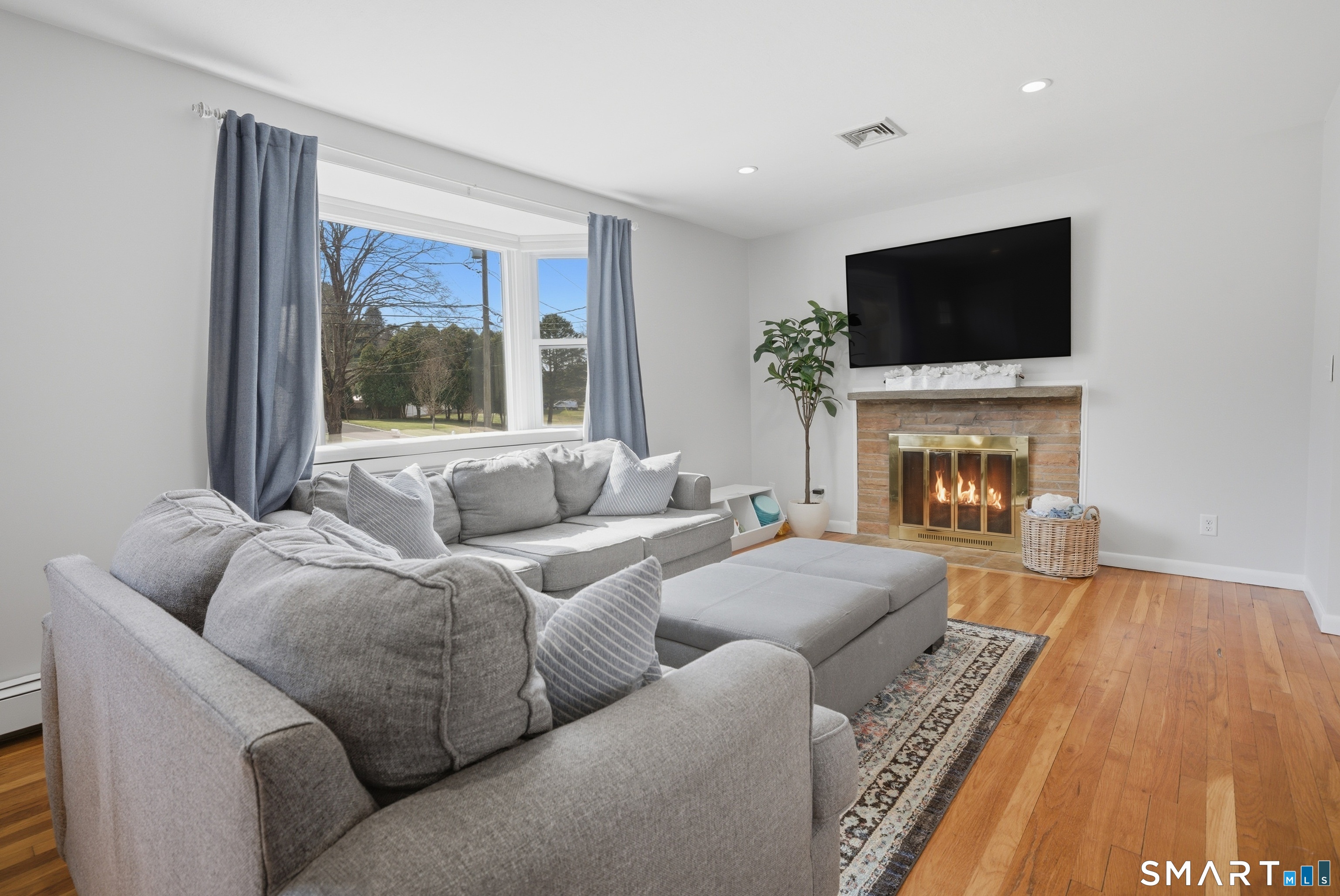 96 Toll House Lane Fairfield, CT 06825 - Photo 5 of 29 a living room with furniture a flat screen tv and a fireplace