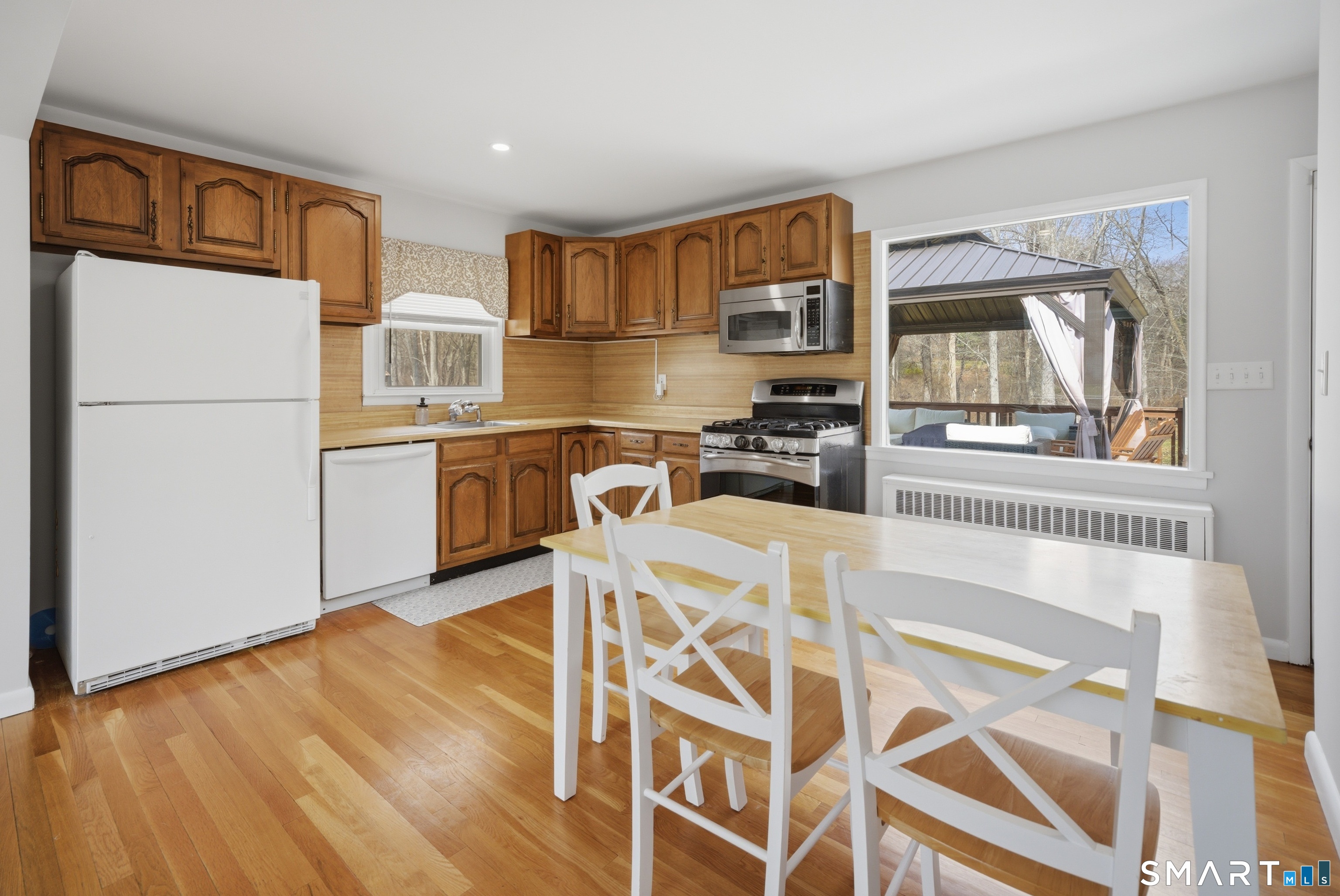 96 Toll House Lane Fairfield, CT 06825 - Photo 8 of 29 a kitchen with stainless steel appliances granite countertop a refrigerator a stove a sink dishwasher and white cabinets with wooden floor