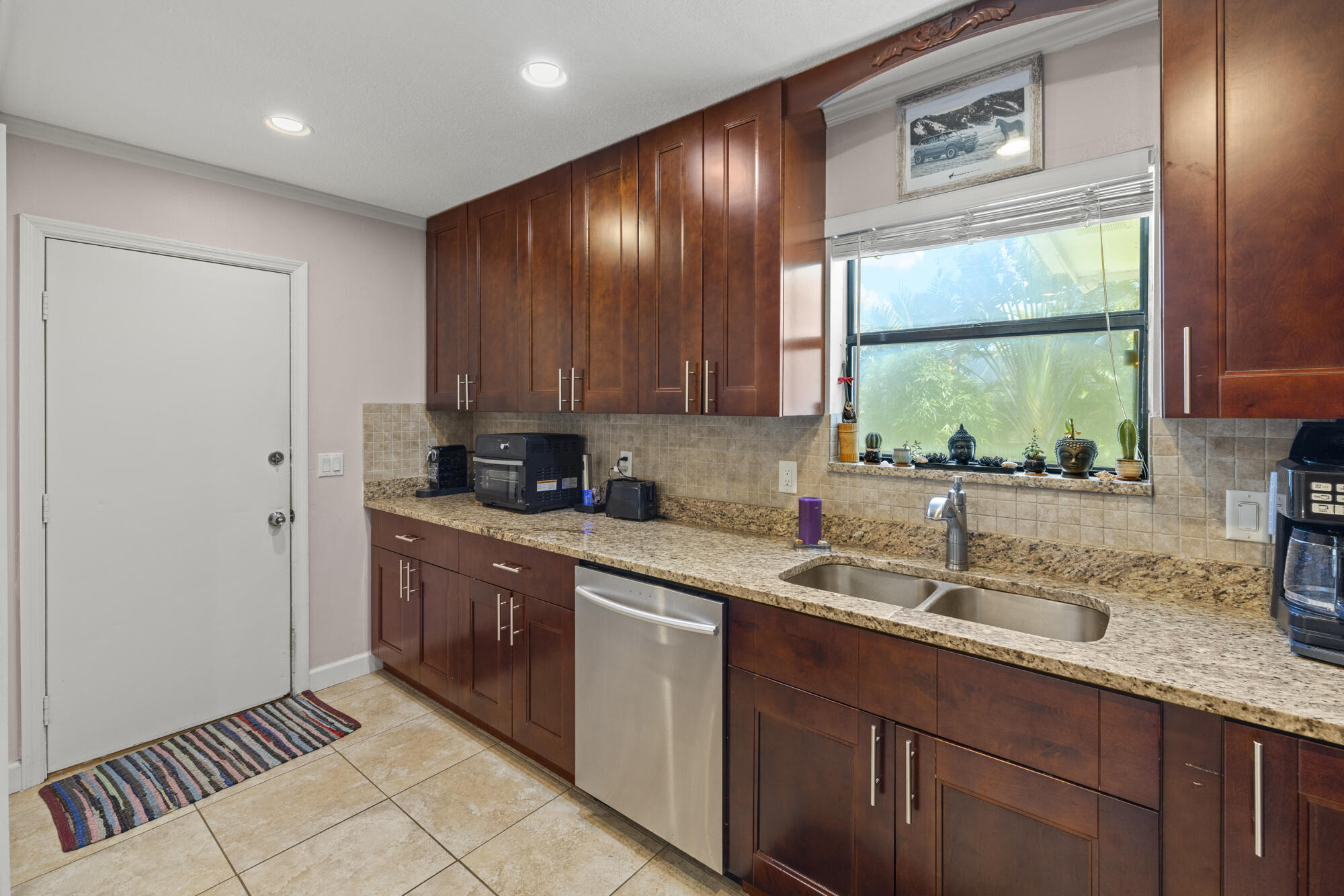 591 Kriss Lane Jupiter, FL 33458 - Photo 12 of 36 a kitchen with a sink window and cabinets
