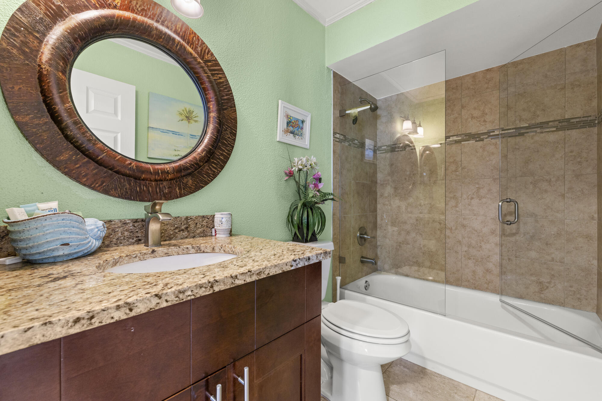591 Kriss Lane Jupiter, FL 33458 - Photo 20 of 36 a bathroom with a granite countertop toilet a sink and a mirror