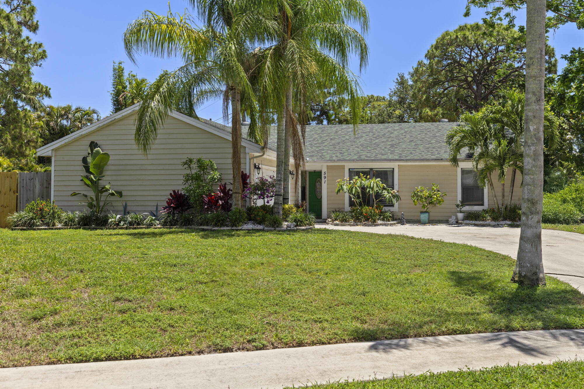 591 Kriss Lane Jupiter, FL 33458 - Photo 2 of 36 a front view of a house with garden