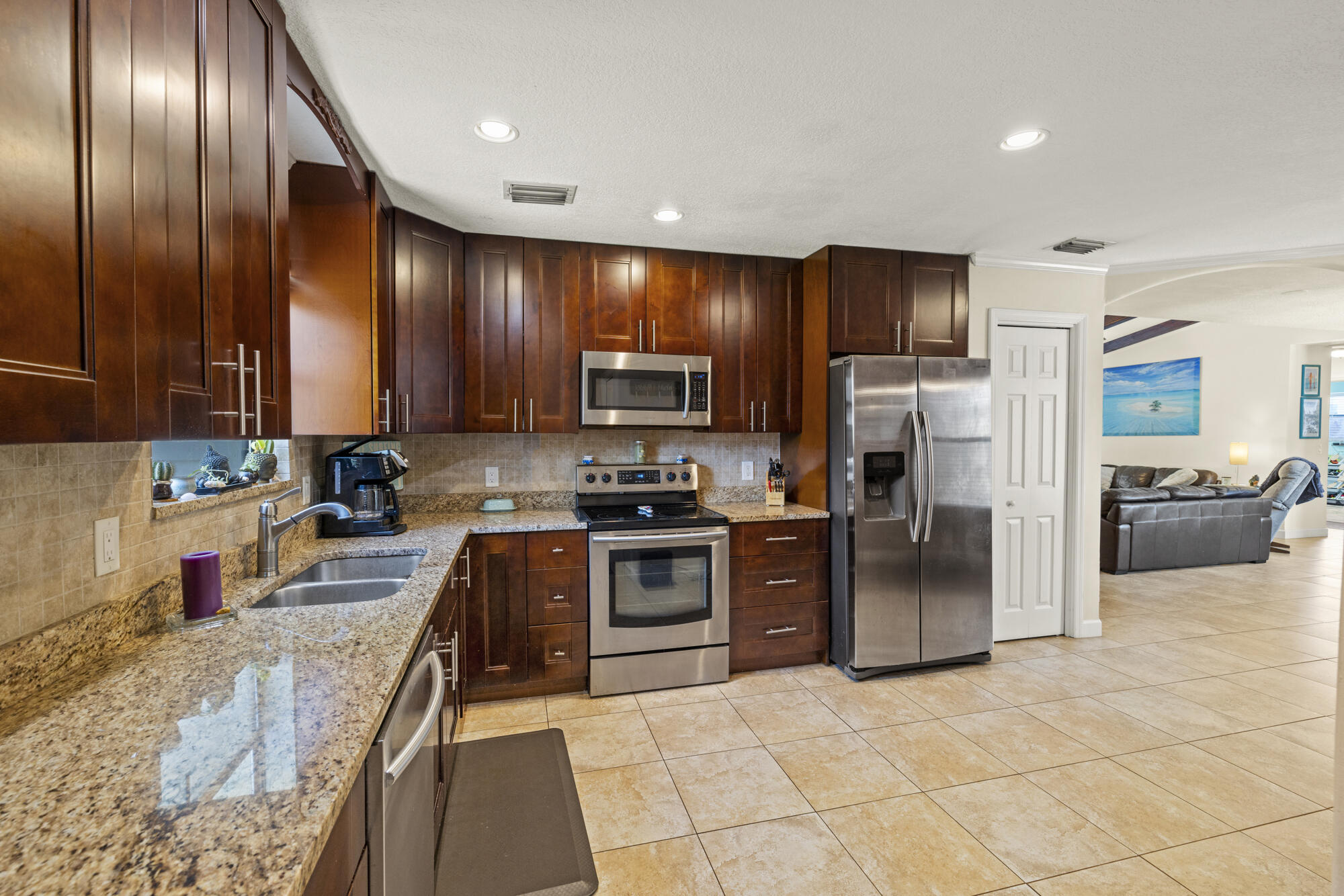 591 Kriss Lane Jupiter, FL 33458 - Photo 10 of 36 a large kitchen with cabinets and stainless steel appliances
