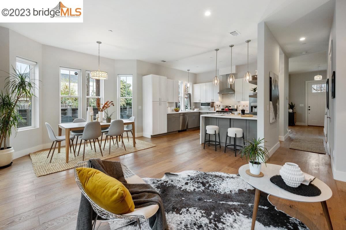 a living room with furniture kitchen view and a wooden floor