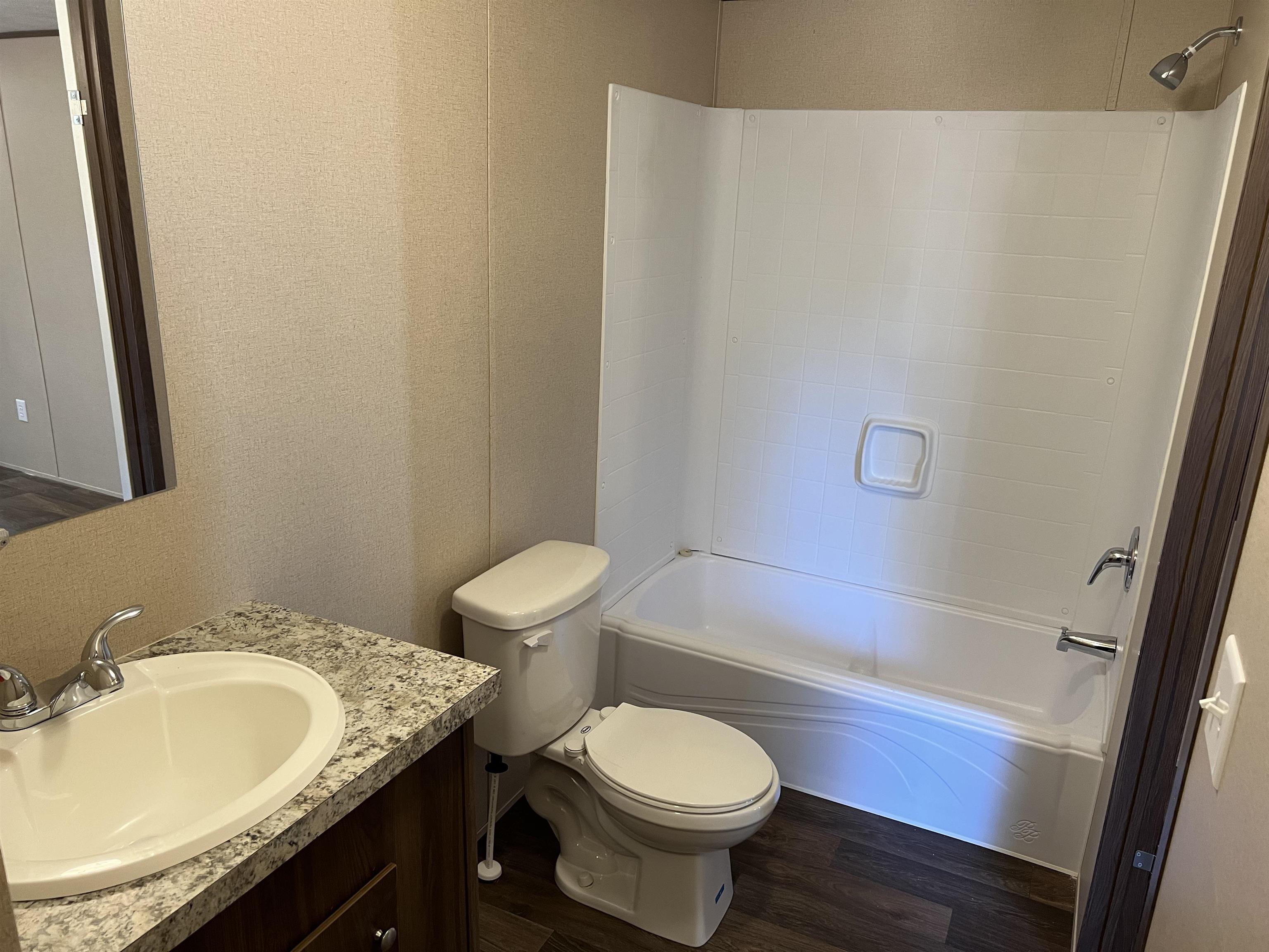 3390 Clifton Road Savannah, TN 38372 - Photo 7 of 12 a bathroom with a granite countertop sink toilet mirror vanity and bathtub
