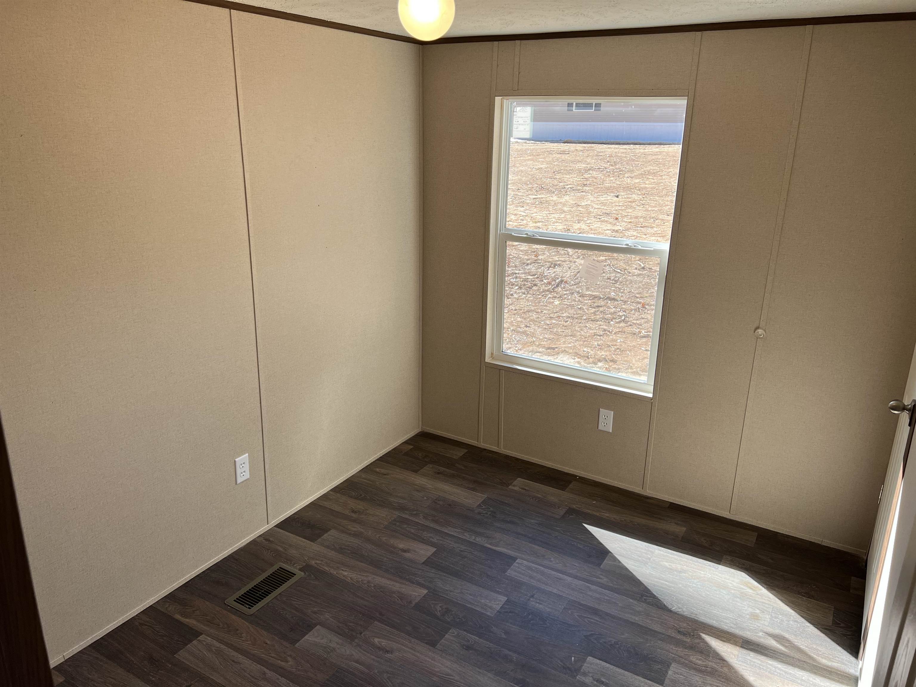 3390 Clifton Road Savannah, TN 38372 - Photo 10 of 12 a view of an empty room with wooden floor and a window