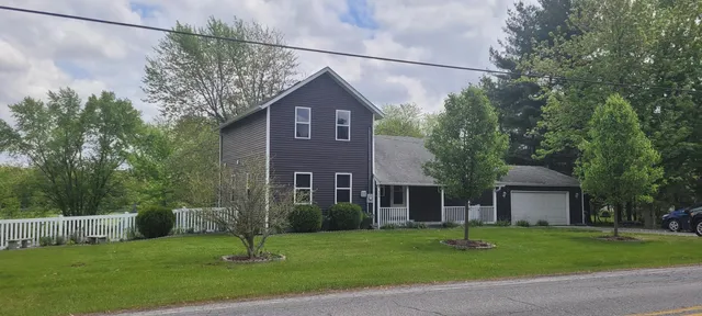 a front view of a house with a yard and trees