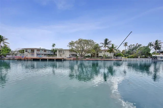 a view of a city next to a lake and trees