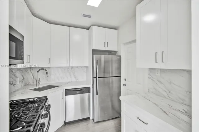 a kitchen with a refrigerator sink and cabinets