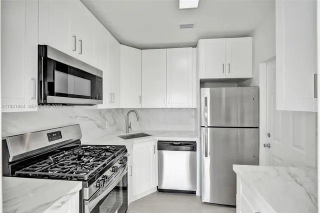 a kitchen with white cabinets and white appliances