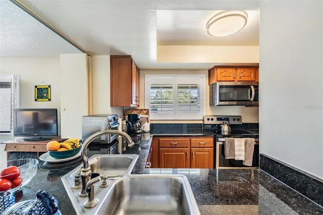 a kitchen with stainless steel appliances a sink a stove and a refrigerator