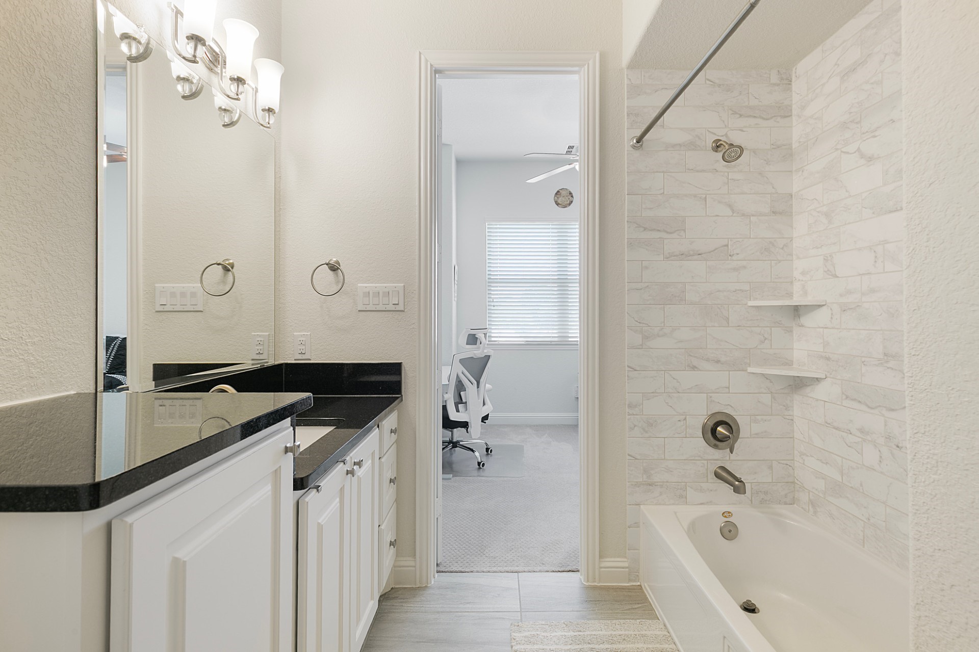 1415 Maple Stream Drive Houston, TX 77043 - Photo 16 of 29 a bathroom with a granite countertop sink a mirror and a bathtub