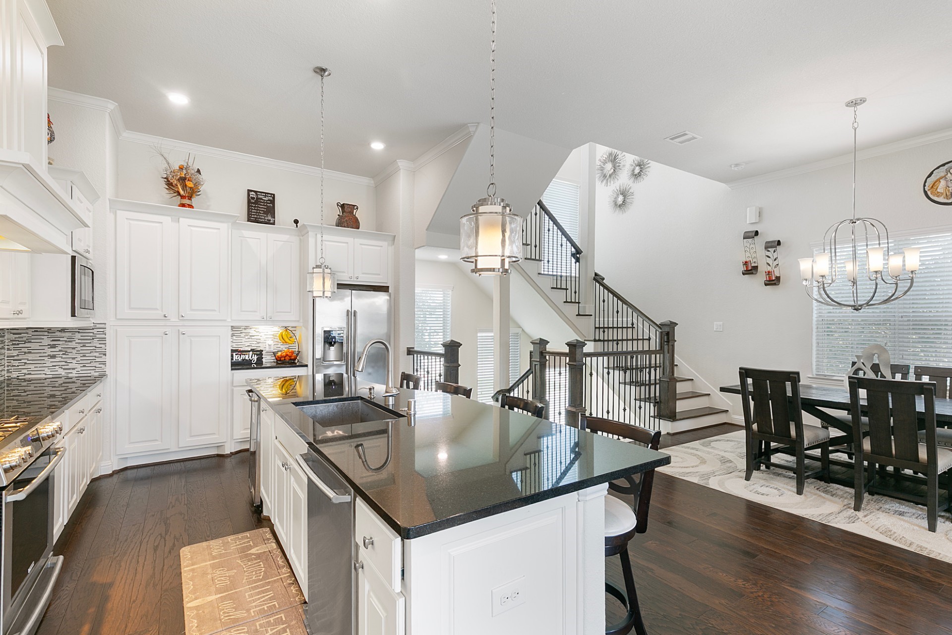 1415 Maple Stream Drive Houston, TX 77043 - Photo 6 of 29 a kitchen with stainless steel appliances granite countertop a sink dishwasher and a dining table with wooden floor