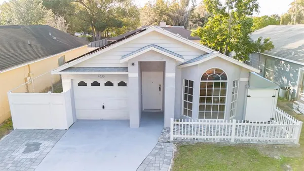 a view of a white house with a large window and wooden fence