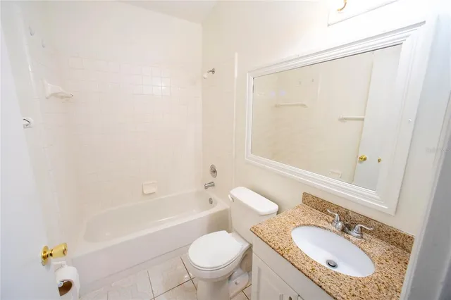 a bathroom with a granite countertop sink a toilet and shower