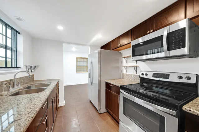 a kitchen with stainless steel appliances granite countertop a sink stove and refrigerator