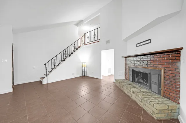 a view of an empty room with wooden floor a fireplace