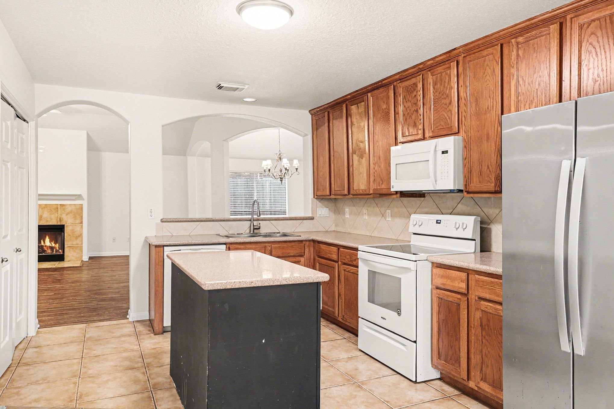 3218 Woodchuck Road Montgomery, TX 77356 - Photo 13 of 27 a kitchen with stainless steel appliances granite countertop a refrigerator a stove and a sink with wooden cabinets