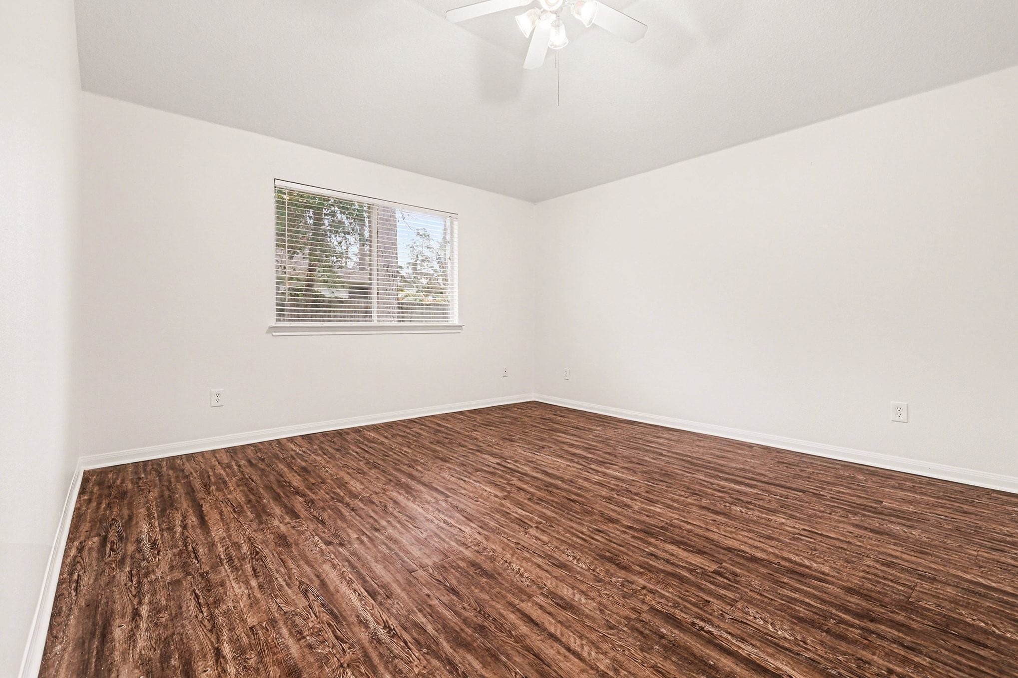 3218 Woodchuck Road Montgomery, TX 77356 - Photo 18 of 27 a view of an empty room with wooden floor and a window