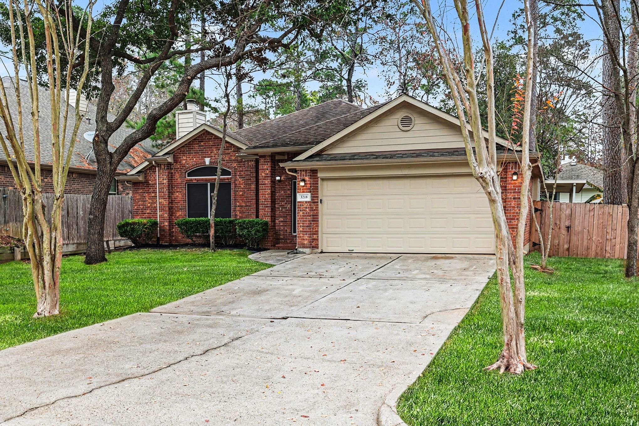 3218 Woodchuck Road Montgomery, TX 77356 - Photo 2 of 27 a view of a white house next to a yard with big trees