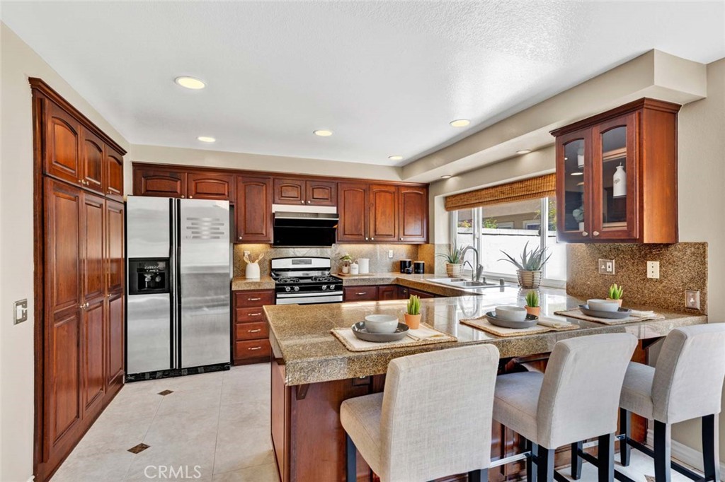 2489 Via Castillo Tustin, CA 92782 - Photo 6 of 30 a kitchen with a table chairs refrigerator and cabinets