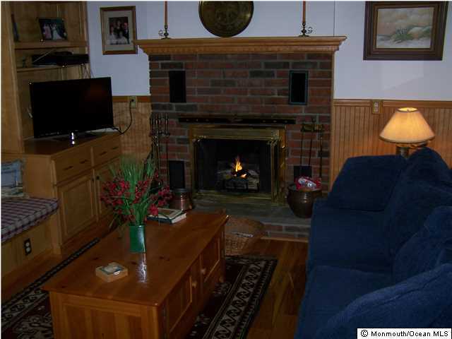 657 Thoroughfare Road Brick, NJ 08724 - Photo 12 of 23 a living room with furniture a flat screen tv and a fireplace