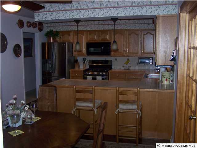 657 Thoroughfare Road Brick, NJ 08724 - Photo 13 of 23 a kitchen with stainless steel appliances a refrigerator and cabinets