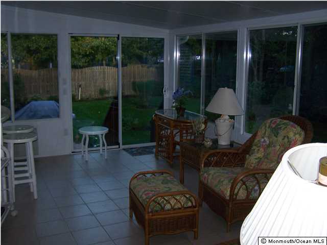 657 Thoroughfare Road Brick, NJ 08724 - Photo 9 of 23 a living room with furniture a lamp and a floor to ceiling window
