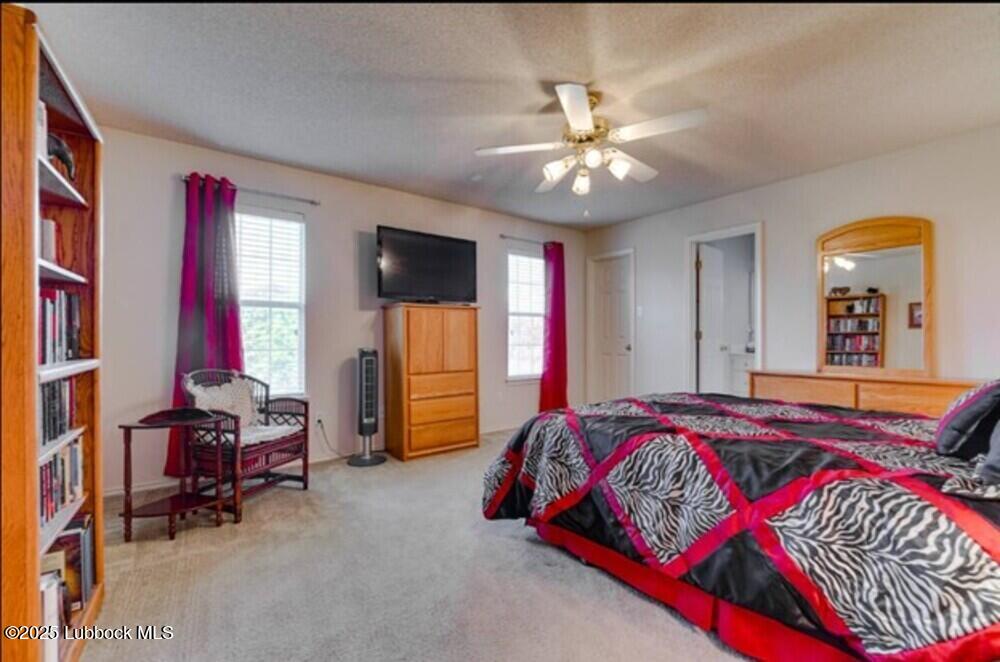 5914 88th Place Lubbock, TX 79424 - Photo 13 of 22 a bedroom with a bed and a chandelier
