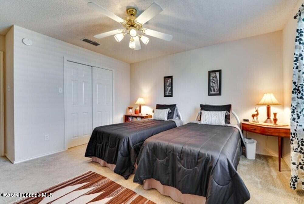 5914 88th Place Lubbock, TX 79424 - Photo 16 of 22 a bedroom with a bed and a chandelier