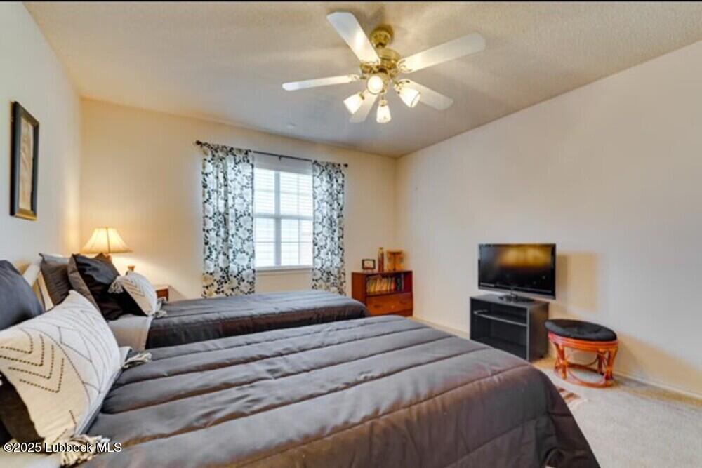 5914 88th Place Lubbock, TX 79424 - Photo 17 of 22 a bedroom with a bed and a flat screen tv