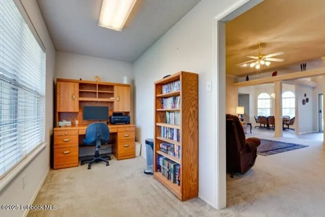 a view of a livingroom with workspace and a window