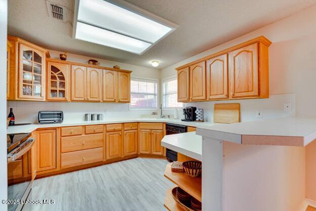 5914 88th Place Lubbock, TX 79424 - Photo 3 of 22 a kitchen with stainless steel appliances granite countertop wooden cabinets a sink and dishwasher with wooden floor
