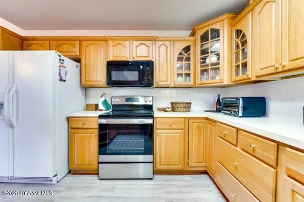 a kitchen with stainless steel appliances granite countertop a refrigerator and a stove top oven