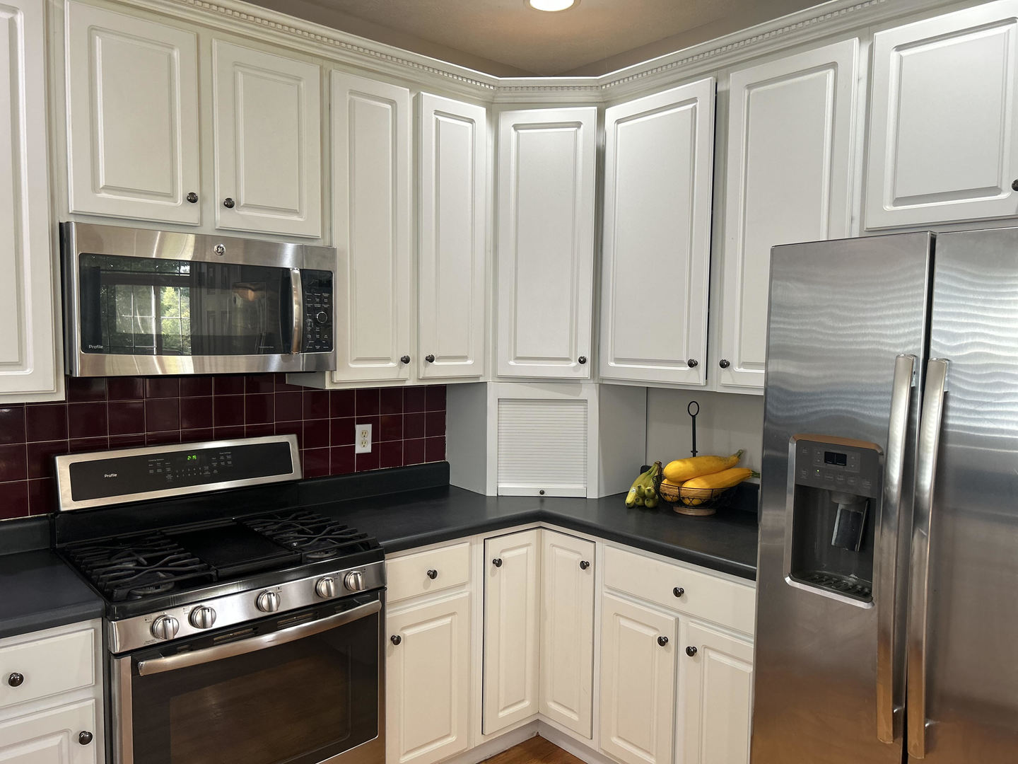 1008 Stuart Drive Heyworth, IL 61745 - Photo 13 of 32 a kitchen with stainless steel appliances a stove a microwave and cabinets